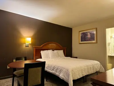 a hotel room with a bed and a table at Country Club Inn & Suites in Fostoria