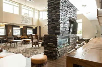 a living room with a fireplace in the center at Residence Inn by Marriott Toledo West in Toledo