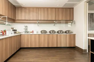 a kitchen with wooden cabinets and wooden floors at Residence Inn by Marriott Toledo West in Toledo