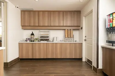 a kitchen with wooden cabinets in a room at Residence Inn by Marriott Toledo West in Toledo