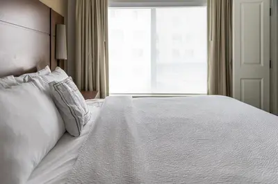 a bedroom with a white bed with a window at Residence Inn by Marriott Toledo West in Toledo