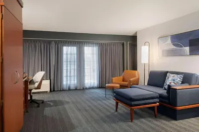 a hotel room with a couch and a chair and a desk at Courtyard by Marriott Columbus New Albany in New Albany