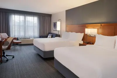 a hotel room with two beds and a desk at Courtyard by Marriott Columbus New Albany in New Albany