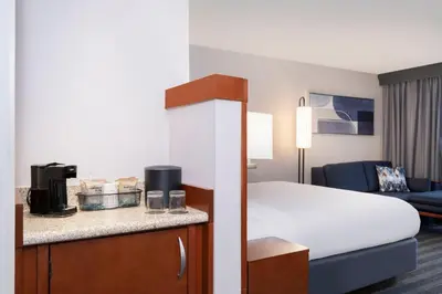 a hotel room with a bed and a living room at Courtyard by Marriott Columbus New Albany in New Albany