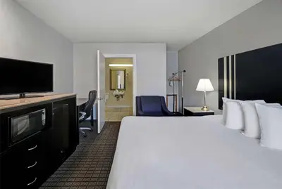 a hotel room with a large bed and a flat screen tv at Motel 6 Washington, PA in Washington