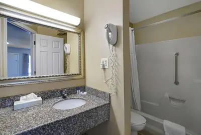 a bathroom with a sink and a phone next to a toilet at Motel 6 Washington, PA in Washington