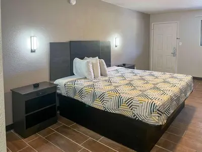 a bedroom with a large bed with a night stand at Motel 6 Hurricane, WV in Hurricane