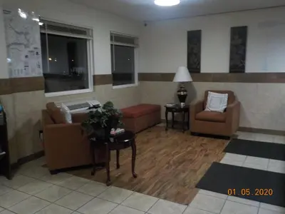 a living room with two chairs and a couch and a table at Motel 6 Hurricane, WV in Hurricane