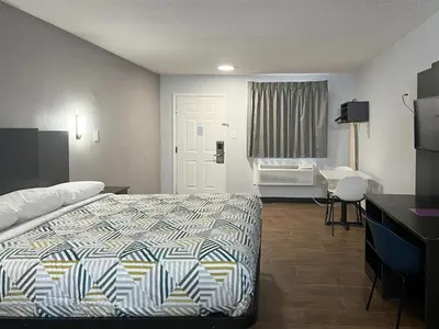 a hotel room with a bed and a desk at Studio 6 Suites Hurricane, WV in Hurricane