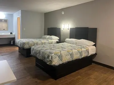 a hotel room with two beds and a bathroom at Studio 6 Suites Hurricane, WV in Hurricane