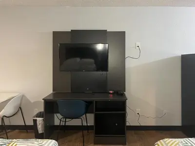 a desk with a tv and a chair in a room at Studio 6 Suites Hurricane, WV in Hurricane