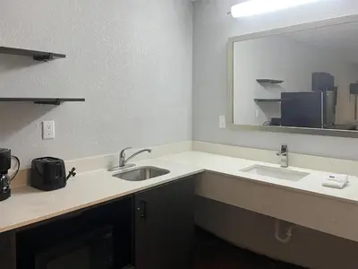 a bathroom with two sinks and a large mirror at Studio 6 Suites Hurricane, WV in Hurricane