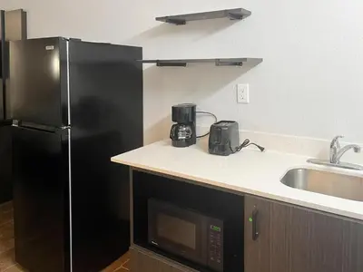 a kitchen with a black refrigerator and a sink at Studio 6 Suites Hurricane, WV in Hurricane