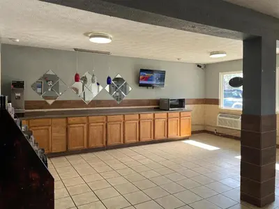 a kitchen with wooden cabinets and a counter top at Studio 6 Suites Hurricane, WV in Hurricane