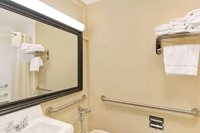 a bathroom with a sink and a mirror and towels at Days Inn by Wyndham Washington in Washington