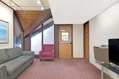 a living room with a couch and a pink chair at Days Inn by Wyndham Washington in Washington