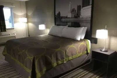 a bedroom with a large bed with two lamps and a bed sidx sidx sidx sidx at Travel Inn Of Sidney Ohio in Sidney
