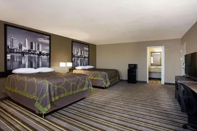 a hotel room with two beds and a flat screen tv at Travel Inn Of Sidney Ohio in Sidney