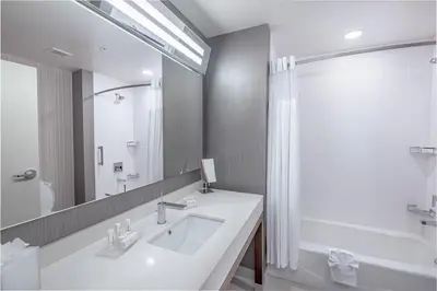a white bathroom with a sink and a mirror at Courtyard by Marriott Toledo West in Toledo