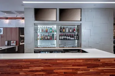 a bar with a counter with bottles of alcohol at Courtyard by Marriott Toledo West in Toledo