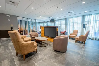 a lobby with chairs and a flat screen tv at Courtyard by Marriott Toledo West in Toledo