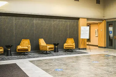 a group of chairs in a room with a wall at Delta Hotels by Marriott Cincinnati Sharonville in Sharonville