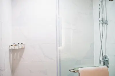 a shower with a glass door in a bathroom at Delta Hotels by Marriott Cincinnati Sharonville in Sharonville