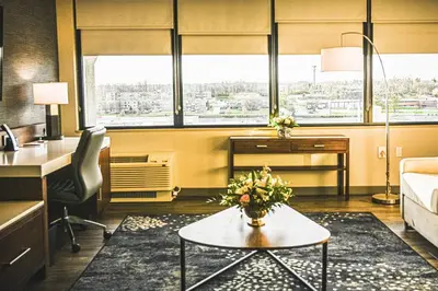 a living room with a couch and a table with flowers at Delta Hotels by Marriott Cincinnati Sharonville in Sharonville