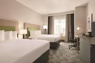 a hotel room with two beds and a desk at Country Inn & Suites by Radisson, Port Clinton, OH in Port Clinton