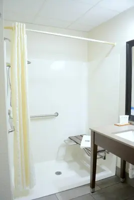 a bathroom with a desk and a shower curtain at Country Inn & Suites by Radisson, Port Clinton, OH in Port Clinton