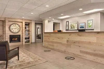 a lobby with a reception desk and a clock at Country Inn & Suites by Radisson, Port Clinton, OH in Port Clinton