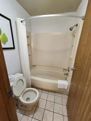 a bathroom with a toilet and a bath tub at WestSpring Inn - Westlake Cleveland in Westlake
