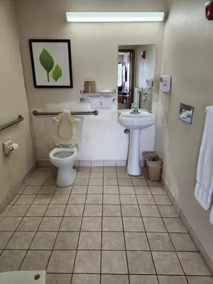 a bathroom with a toilet and a sink at WestSpring Inn - Westlake Cleveland in Westlake