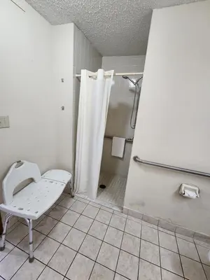 a bathroom with a shower and a toilet in it at WestSpring Inn - Westlake Cleveland in Westlake