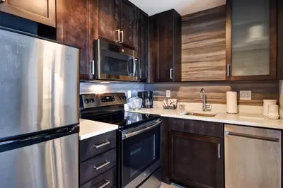 a kitchen with wooden cabinets and a stainless steel refrigerator at Residence Inn by Marriott Cincinnati Northeast/Mason in Mason