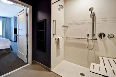 a bathroom with a walk in shower next to a bed at Residence Inn by Marriott Cincinnati Northeast/Mason in Mason