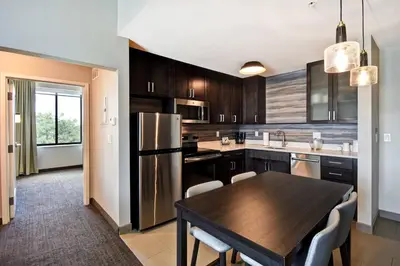 a kitchen with a wooden table and a dining room at Residence Inn by Marriott Cincinnati Northeast/Mason in Mason