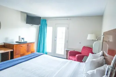 a hotel room with a bed and a red chair at Islander Inn in Put-in-Bay