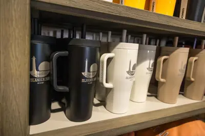 a row of coffee mugs sitting on a shelf at Islander Inn in Put-in-Bay