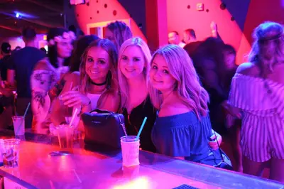 three women sitting at a bar at a party at Grand Islander Hotel in Put-in-Bay