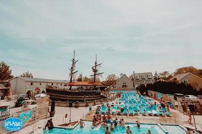 a group of people in a pool next to a pirate ship at Grand Islander Hotel in Put-in-Bay