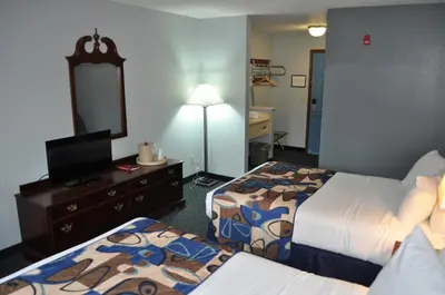 a hotel room with two beds and a mirror at Grand Islander Hotel in Put-in-Bay