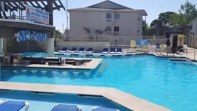 a large swimming pool with blue chairs in a building at Grand Islander Hotel in Put-in-Bay