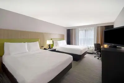 a hotel room with two beds and a flat screen tv at Country Inn & Suites by Radisson, Cincinnati Airport, KY in Hebron