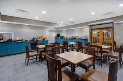 a restaurant with tables and chairs and a counter at Country Inn & Suites by Radisson, Cincinnati Airport, KY in Hebron