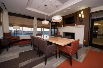 a dining room with a table and chairs and a fireplace at Hilton Garden Inn Dayton South - Austin Landing in Springboro