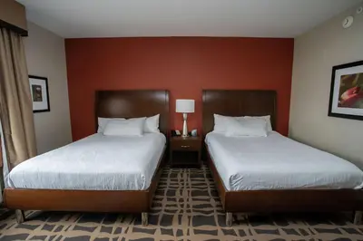 two beds in a hotel room with red walls at Hilton Garden Inn Dayton South - Austin Landing in Springboro