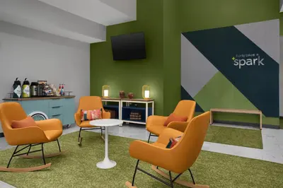 a waiting room with chairs and a table and a tv at Spark by Hilton Washington Meadowlands Blvd in Washington