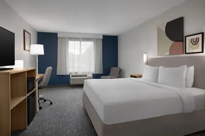 a hotel room with a large bed and a television at Spark by Hilton Washington Meadowlands Blvd in Washington