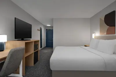 a hotel room with a bed and a tv at Spark by Hilton Washington Meadowlands Blvd in Washington